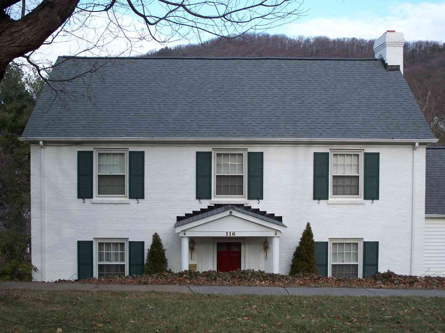 A white single family residential home with a dark gray roof