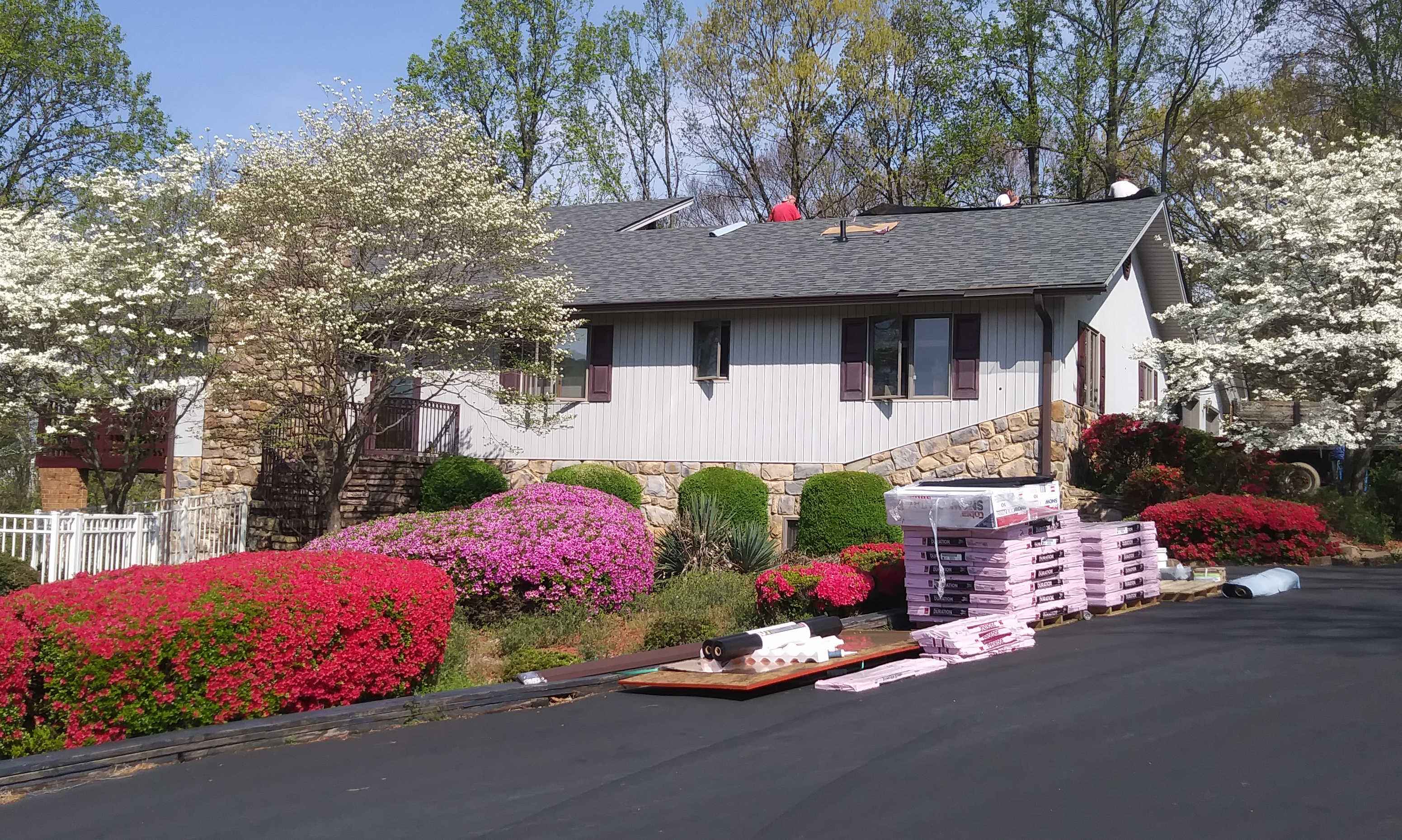 Roofers finishing up work on beautiful single story home